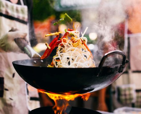 Man cooks noodles on the fire on our blog stories