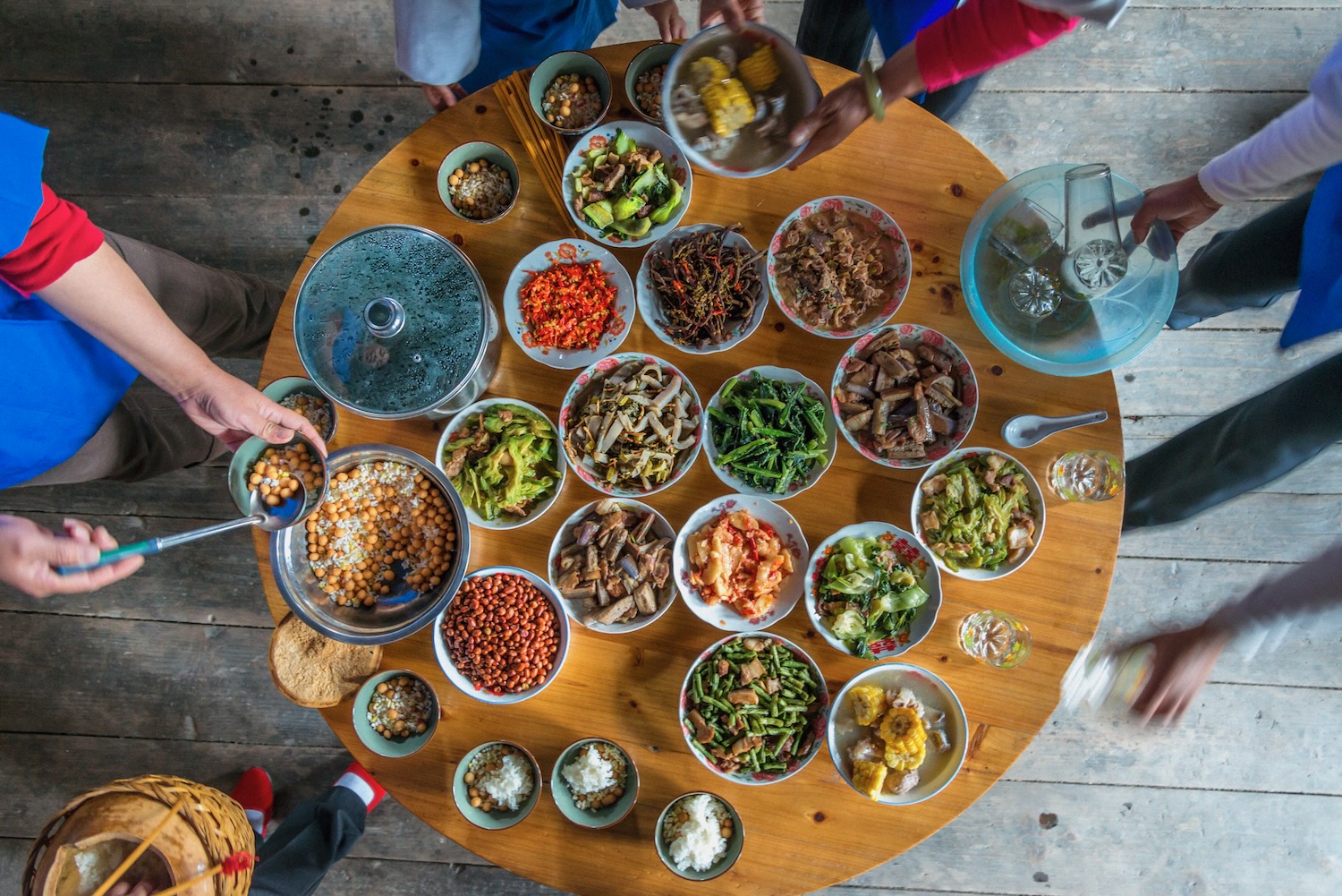 Chinese dinner in a rural Dong (ethnic group) house. Fish stew, stir fry veg and meat, pickles and ingredient to make Dong oil tea; tea, fried rice, and fried peanuts.