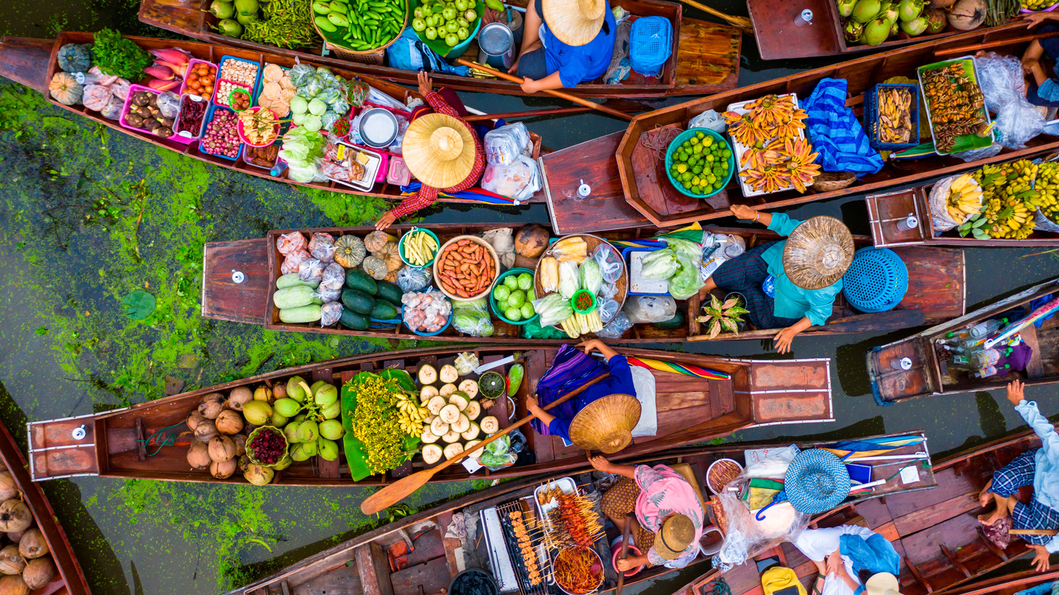 Aerial view famous floating market in Thailand, Damnoen Saduak floating market, Farmer go to sell organic products, fruits, vegetables and Thai cuisine, Tourists visiting by boat, Ratchaburi, Thailand food stories