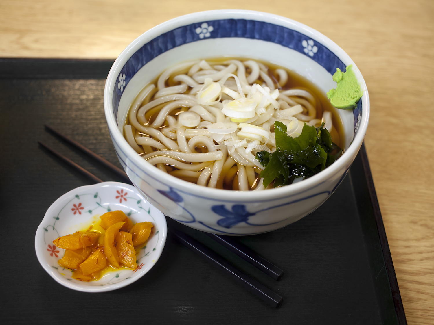Udon served in bowl with takuan aside on serving tray