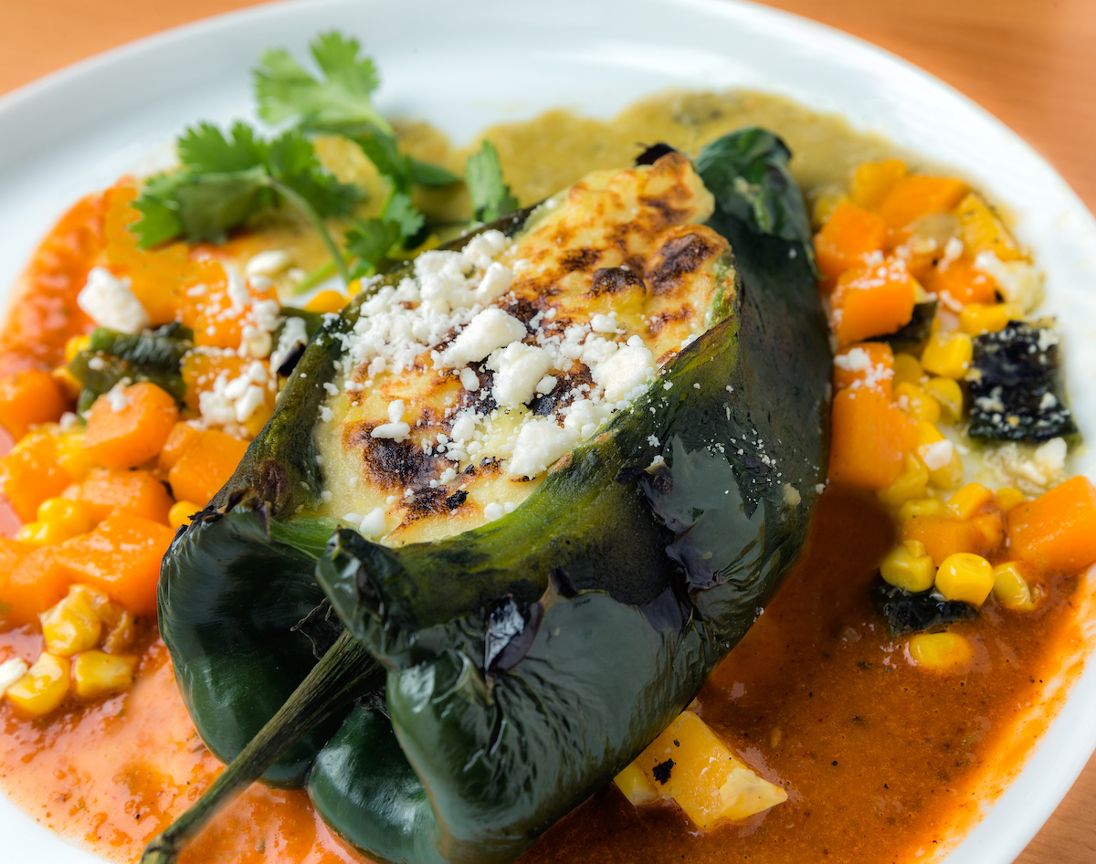 Chile Relleno stuffed with mashed potatoes served with squash and corn hash.
