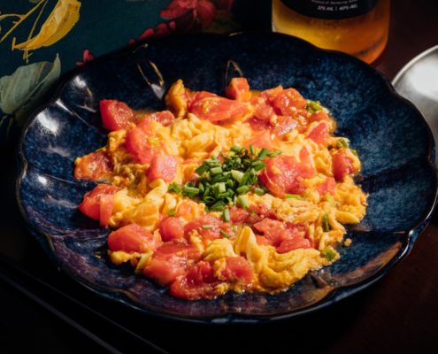 Stir fried tomato and eggs in blue dish