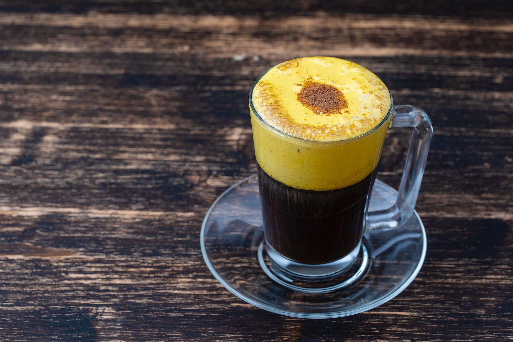 Traditional vietnamese egg coffee made of raw egg yolk and condensed milk, close up. Eggcoffee on wooden table background